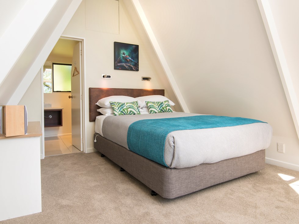 Koru Chalet accommodation rooms include a comfortable bedroom area with a Queen bed and side kitchenette at Punga Cove in the Marlborough Sounds in New Zealand's top of the South Island