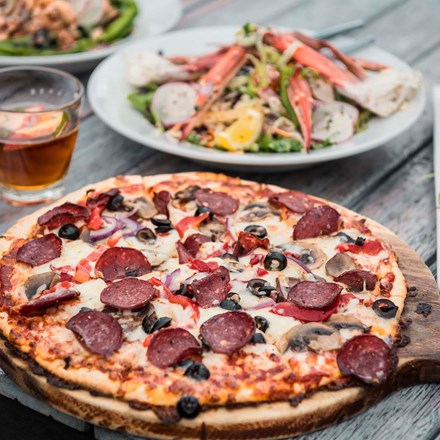 Enjoy choosing from a variety of sharing options at the Boatshed Cafe and Bar like hot stone baked pizzas, smaller plates and more at Punga Cove in the Marlborough Sounds