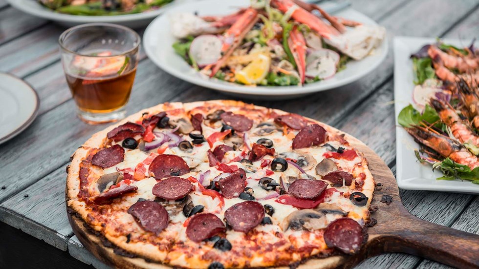 Enjoy choosing from a variety of sharing options at the Boatshed Cafe and Bar like hot stone baked pizzas, smaller plates and more at Punga Cove in the Marlborough Sounds