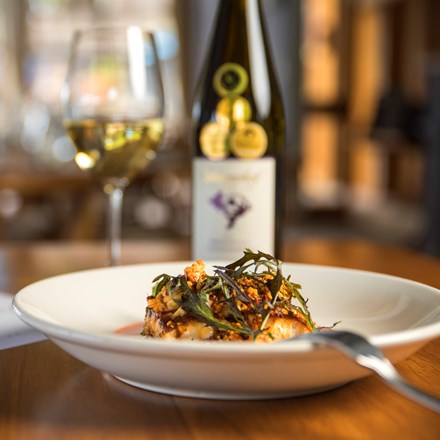 The Punga Fern Restaurant menu can include meals like this fresh Groper dish matched with a glass of local Marlborough wine at Punga Cove in the Marlborough Sounds of New Zealand's South Island