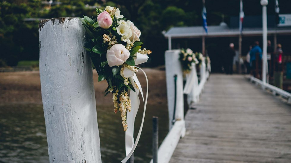 Beautiful floral bouquets are tied to the Punga Cove jetty to welcome guests for a wedding in Endeavour Inlet in the Marlborough Sounds, New Zealand
