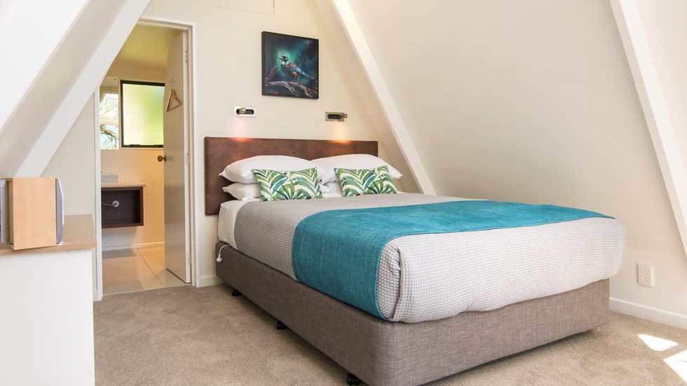 Koru Chalet accommodation rooms include a comfortable bedroom area with a Queen bed and side kitchenette at Punga Cove in the Marlborough Sounds in New Zealand's top of the South Island